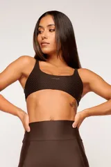 Top deportivo color verde oscuro, con tirantes finos y espalda descubierta. Diseño reversible con un lado brillante y otro con textura 3D tipo colmena.