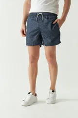 Short de baño con estampado abstracto en tonos azul oscuro, cintura elástica con cordón ajustable, bolsillos laterales y bolsillo trasero.