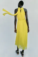 Vestido midi amarillo con diseño plisado, cuello halter y cintura elástica.