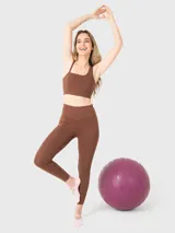 Calza deportiva de tiro alto con largo al tobillo, confeccionada en tejido técnico elástico de color marrón chocolate.