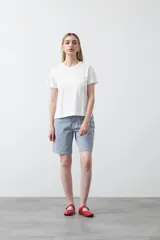 Remera negra de algodón de manga corta, cuello redondo y pequeñas aberturas en los laterales.