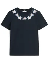 Remera de algodón Tommy Hilfiger en color azul marino, con cuello redondo y mangas cortas. Presenta un delicado diseño bordado de flores alrededor del escote y el pequeño logo de la bandera de la marca en la manga.