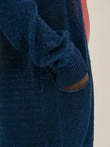 Cardigan largo azul tejido en jersey con lurex, con bolsillos en el frente y detalle en cobre con logo.