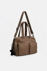 Cartera Rapsodia tipo morral acolchado color marrón con costuras romboidales, doble asa de mano y correa larga ajustable. Cuenta con dos bolsillos frontales con cierre y llavero colgante con pompones.