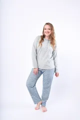 Pijama de dos piezas compuesto por una remera de manga larga con cuello redondo y cartera de botones, y un pantalón largo de corte recto. Ambas prendas presentan un estampado geométrico sutil en tonos gris y azul.