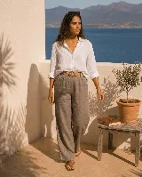 Pantalón de lino color verde oscuro, de corte ancho y relajado, con cintura elástica y cinto de rafia con hebilla redonda.