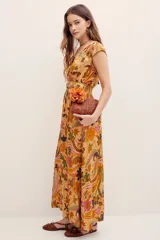 Vestido largo color mostaza con estampado paisley y floral, cuello en V, mangas cortas y cintura elastizada fruncida.