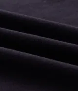 Remera masculina de corte boxy, color negro, con cuello redondo y mangas cortas amplias. Presenta detalles de vivos blancos en contraste a lo largo de las costuras de las mangas y hombros.