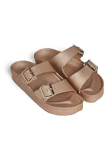 Sandalia tipo Birkenstock de goma color dorado, con doble tira ajustable con hebillas metálicas y suela anatómica.