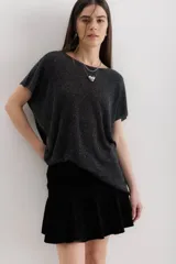 Blusa de punto con acabado brillante de lurex, color negro, de corte holgado y mangas cortas con caída relajada.