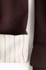 Blazer de sarga color bordó con solapas de pico, frente abierto y bolsillos delanteros ribeteados con solapa.