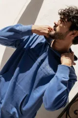 Canguro azul con capucha y bolsillo tipo canguro, estampado con texto en el frente.