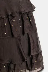 Minifalda marrón oscuro con tres capas de volantes y lentejuelas doradas aplicadas sobre la tela.