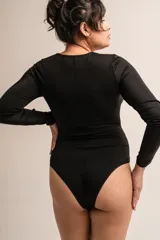 Body negro de lycra de manga larga con detalle de tiras y brillos en los hombros y broches en la entrepierna con fundillo de algodón.