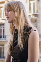 Vestido largo sin mangas confeccionado en velour suave. Presenta un diseño entallado con cuello alto y un efecto drapeado creado mediante pliegues estratégicos en el hombro y en el lateral de la cintura.