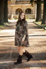 Vestido corto de lino con estampado floral en tonos tierra, verde y marrón. Presenta cuello redondo, mangas tres cuartos con volumen y silueta holgada.