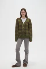 Cardigan de punto con diseño de cuadros, cuello en V y cierre frontal con botones. Presenta un corte holgado y mangas largas con puños acanalados.