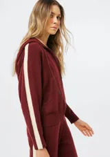 Campera de punto con cierre frontal, capucha con cordones ajustables y bolsillos tipo canguro. Presenta un diseño de manga larga con detalles acanalados en los laterales y puños.