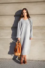 Mochila tipo bucket color marrón tostado, confeccionada en gamuza con detalles en cuero color beige. Cuenta con bolsillo exterior con cierre, bolsillo interior con cierre, llavero interno, asa de mano y correa extraíble y regulable para usar como mochila o bolso de hombro.