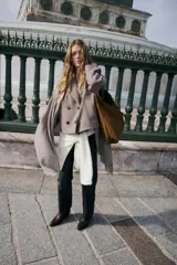 Abrigo corto de paño en color marrón chocolate, con cuello de solapa, cierre frontal cruzado con botones y mangas largas con detalle de trabilla y botón en los puños.