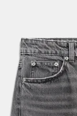 Jeans de tiro alto con corte mom fit, cinco bolsillos y cierre frontal con cremallera y botón metálico.