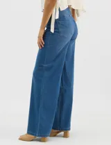 Jegging de denim azul oscuro con silueta estilo palazzo, tiro alto y pierna amplia, con pretina ancha elástica y sin bolsillos frontales.