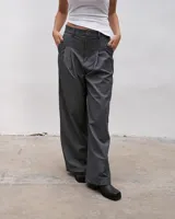 Pantalón sastrero gris de corte ancho con pinzas en la cintura y bolsillos laterales.