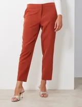 Pantalón de crepe color terracota, de corte recto y largo al tobillo. Presenta detalle fruncido en los bolsillos delanteros y pretina con broche interno y cierre.