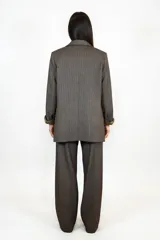 Blazer de corte clásico en color marrón chocolate con textura sutil, solapas tradicionales, bolsillos laterales funcionales y forro interior a tono.