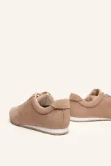 Zapatilla de gamuza color bordó con cordones bicolores, interior de cuero vacuno y suela de caucho blanca y beige.
