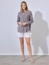 Camisa celeste con rayas verticales blancas, de corte clásico, cuello a la base, escote en V y cierre frontal con botones.