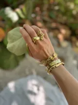 Pulsera tipo esclava abierta con diseño rústico y acabado irregular, fabricada en bronce y alpaca.