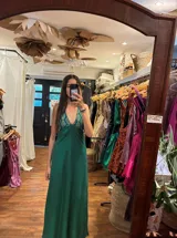 Vestido largo con estampado tie-dye en tonos violeta y fucsia, escote en V con detalles bordados dorados, cut-outs laterales bajo el busto y tirantes finos que se cruzan y atan en la espalda.