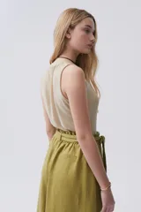 Top corto de lurex color dorado, sin mangas y con cuello a la base.
