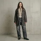 Chaqueta de cuero con acabado texturizado, corte recto y largo medio. Presenta cuello camisero, cierre frontal con cremallera y solapa con botones a presión, bolsillos laterales con solapa y puños ajustables con trabillas.