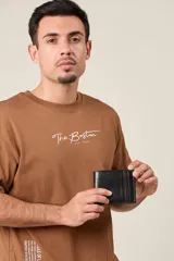 Billetera de cuero negro con franja decorativa marrón en el lateral. Diseño clásico con múltiples compartimentos para tarjetas y billetes.