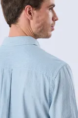 Camisa de manga larga confeccionada en mezcla de lino y algodón, con diseño de rayas finas, cuello camisero y cierre frontal de botones.