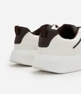 Championes de caña baja en PU color blanco, con recortes contrastantes en marrón y cordones al tono. Cuentan con suela robusta y diseño urbano.