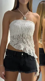 Top strapless de encaje blanco con diseño asimétrico y textura arrugada.