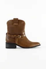 Bota de media caña de cuero color marrón, con taco bajo, puntera ligeramente perfilada y tira decorativa con hebilla metálica alrededor del tobillo.