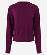 Suéter negro de punto leve, corte boxy, cuello redondo y mangas largas con puños y bajo acanalados.