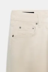 Jeans de tiro medio con corte slim leg, confeccionados en denim color beige. Presentan cintura con trabillas, diseño clásico de cinco bolsillos y cierre frontal con cremallera y botón metálico.