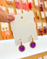 Aros colgantes con argolla dorada y dije circular color violeta con borde de strass.