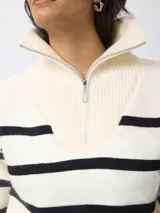 Sweater de punto con diseño a rayas horizontales negras sobre fondo blanco, cuello alto con cierre frontal y mangas largas.