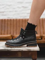 Borcego de cuero negro con cordones, suela track color caramelo y taco de 5 cm.