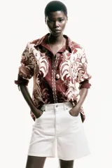 Camisa de viscosa con diseño estampado, corte oversized, cuello clásico, botones ocultos en la parte delantera y mangas largas.