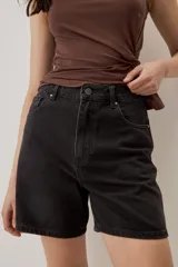 Bermuda de jean de tiro alto y corte amplio color negro, con bolsillos delanteros y costuras pespunteadas a la vista.
