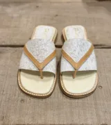 Sandalias de cuero color beige con estampado craquelado y tiras cruzadas color marrón.