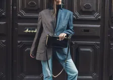 Bandolera negra de charol con correa fina y herrajes dorados.