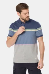 Remera polo de manga corta con diseño de franjas horizontales en tonos azul, gris, verde y detalles en rosado. Cuenta con cuello clásico y cierre frontal de botones.